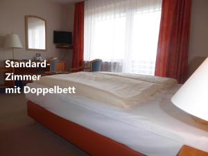 een bed in een kamer met een raam en een nachtkastje bij Sonnenhof in Lügde