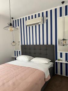 1 dormitorio con 1 cama con rayas azules y blancas en Apartments Brač, en Supetar
