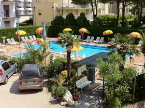 a car parked next to a swimming pool with umbrellas at Hotel Altinate in Lido di Jesolo