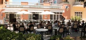 a group of people sitting at tables with umbrellas at Apartamento El olivo in Empuriabrava