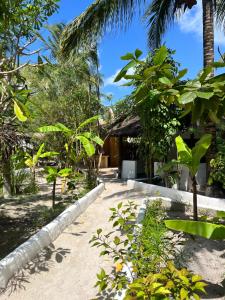 a path leading to a house with palm trees at Karanga Bungalows in Michamvi