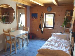 a room with a table and a bed and a table and chairs at Homestay Sleepy Traveler in Sankt Georgen im Attergau