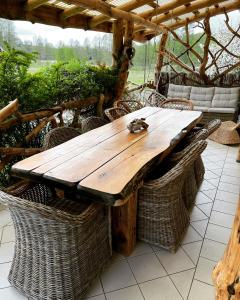 a wooden table with wicker chairs on a patio at CHILL Village in Nowinka