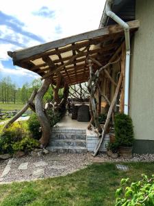 a wooden pergola on the side of a house at CHILL Village in Nowinka