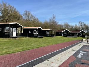 une rangée de cabines noires dans un parc dans l'établissement Myrhoj Camping, à Myrhøj