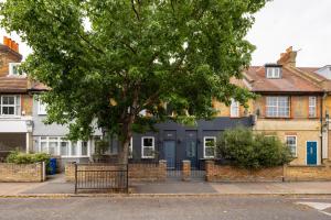 a blue house with a tree in front of it at The East Dulwich House in London