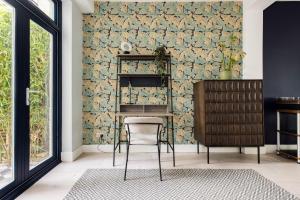 a dining room with a chair and a wall of wallpaper at The East Dulwich House in London
