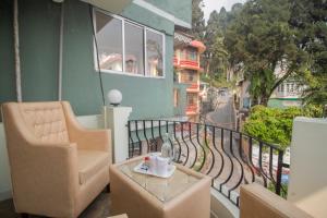 a balcony with a chair and a table on a balcony at Hotel Himalayan Retreat in Darjeeling