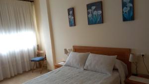 een slaapkamer met een bed en drie foto's aan de muur bij Beiramar2 in Muxia