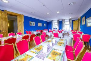 een kamer met tafels en stoelen in een kamer met blauwe muren bij Hotel Schloss Nebra in Nebra