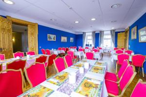 ein Zimmer mit Tischen und Stühlen in einem Zimmer mit blauen Wänden in der Unterkunft Hotel Schloss Nebra in Nebra