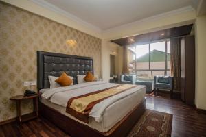 a bedroom with a large bed and a large window at Hotel Himalayan Retreat in Darjeeling