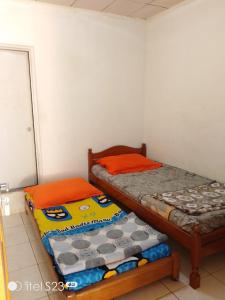 sypialnia z 2 łóżkami pojedynczymi w pokoju w obiekcie PONDOK SITI RAWIYAH Guest House w mieście Bukittinggi
