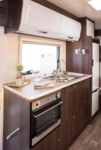 a kitchen with a sink and a stove at easicampers in Wigan