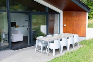 una mesa de madera y sillas blancas en el patio en Villas Winterberg, en Winterberg