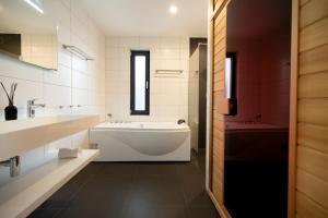 a bathroom with a tub and a sink at Villas Winterberg in Winterberg