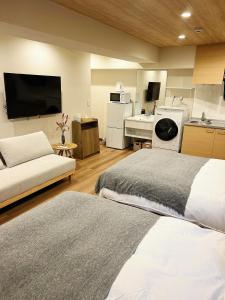 um quarto com 2 camas e uma cozinha com um lavatório em akihabara k em Tóquio