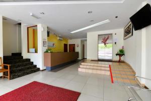 a lobby with a red rug and stairs in a building at Fumah Hotel Shah Alam in Shah Alam