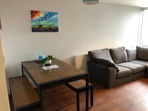 a living room with a couch and a table at Charming 2-Bed Apartment in Christchurch in Christchurch