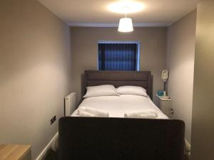 - une petite chambre avec un lit et deux oreillers dans l'établissement Charming 2-Bed Apartment in Christchurch, à Christchurch