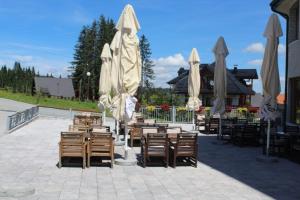 eine Gruppe von Tischen und Stühlen mit Sonnenschirmen in der Unterkunft IN Hotel Zlatar ex Zlatarski Biseri in Nova Varoš