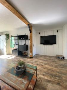 a living room with a table and a flat screen tv at Het Dirkbosje in Middelharnis