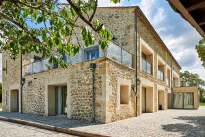 - une vue extérieure sur un bâtiment en briques doté de fenêtres en verre dans l'établissement Domaine de Badine, 15 min Bordeaux & Saint-Emilion, à Saint-Sulpice-et-Cameyrac