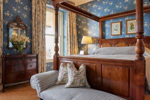 金塞爾的住宿－佩里維爾樓酒店，一间卧室配有一张天蓬床和一把椅子
