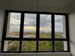 a window in a room with a view of a field at TWC Luxury Seaview Suites Bali Residences Malacca in Melaka