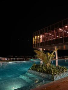 a swimming pool in front of a building at night at TWC Luxury Seaview Suites Bali Residences Malacca in Melaka