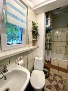 baño con aseo y lavabo y ventana en Seaside Holiday House en Gdansk