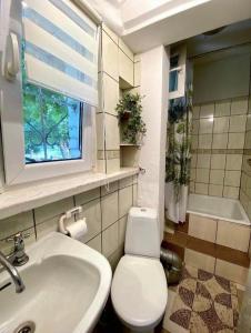 a bathroom with a toilet and a sink and a window at Seaside Holiday House in Gdańsk +13 photos