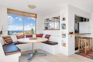 a living room with a table and chairs and a window at The Edward at Bondi - A Blissful Beachside Retreat in Sydney