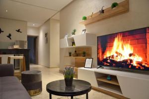 uma sala de estar com lareira e televisão em Sumptuous Appartement Y&M em Marrakech