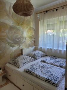 uma cama num quarto com uma parede de flores em Boglar Vintage em Balatonboglár