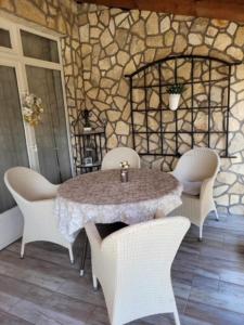 uma mesa e cadeiras num quarto com uma parede de pedra em Boglar Vintage em Balatonboglár
