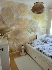 a bedroom with a mural of roses on the wall at Boglar Vintage in Balatonboglár