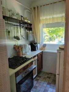 uma cozinha com um fogão, um lavatório e uma janela em Boglar Vintage em Balatonboglár
