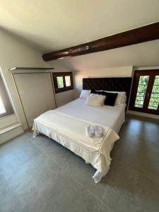 a bedroom with a large white bed with two shoes on it at Prestige Sirmione Via Antiche Mura in Sirmione