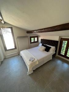 a bedroom with a large white bed and windows at Prestige Sirmione Via Antiche Mura in Sirmione