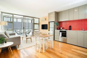 Il comprend une cuisine et un salon avec une table et des chaises. dans l'établissement Ultra modern Inner-city Lifestyle in Darlinghurst, à Sydney