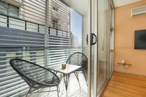 d'un balcon avec deux chaises et une table devant une fenêtre. dans l'établissement Ultra modern Inner-city Lifestyle in Darlinghurst, à Sydney
