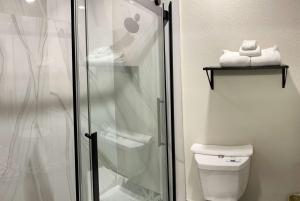 a bathroom with a toilet and a glass shower at Days Inn by Wyndham Arlington in Arlington