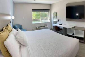 a bedroom with a large white bed and a desk at Days Inn by Wyndham Arlington in Arlington