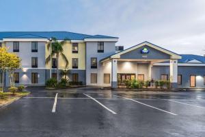 a hotel with a parking lot in front of it at Days Inn & Suites by Wyndham Lakeland in Lakeland