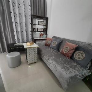sala de estar con sofá con almohadas y mesa en Beach side Private Room for Travelers, en Sharjah
