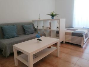 ein Wohnzimmer mit einer Couch und einem Tisch in der Unterkunft Helios Studio Drago in Costa Del Silencio