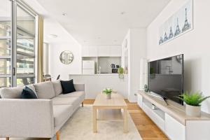 a white living room with a couch and a table at 'Sussex Suite' Sunny City Living by Darling Harbour in Sydney