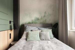 a bedroom with a bed with a painting on the wall at Apartament SezamkowaSKC in Skierniewice