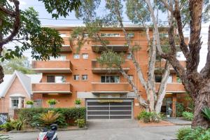an orange brick building with a garage at Cosy Inner-city Hideaway in the Heart of Annandale in Sydney
